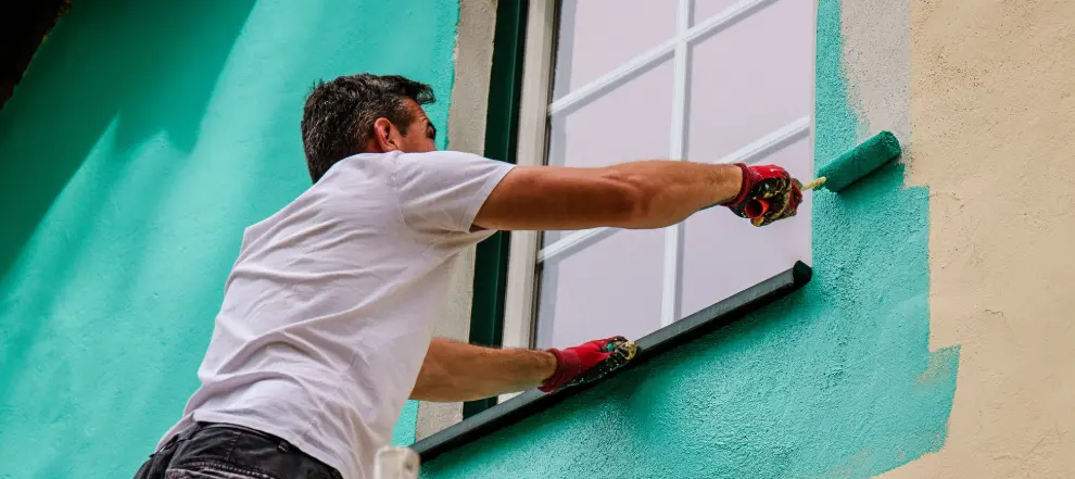 Man painting outside wall